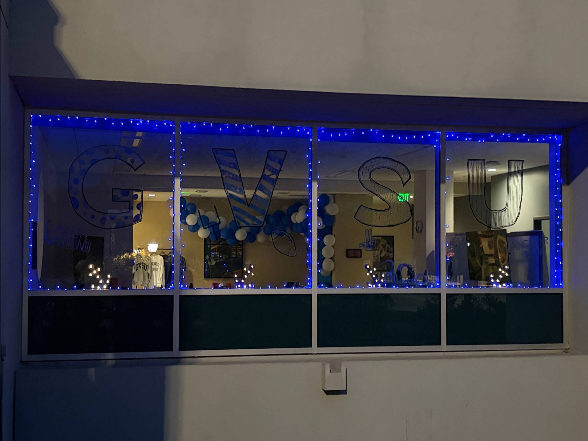 Blue twinkle lights in campus-facing window in Zumberge